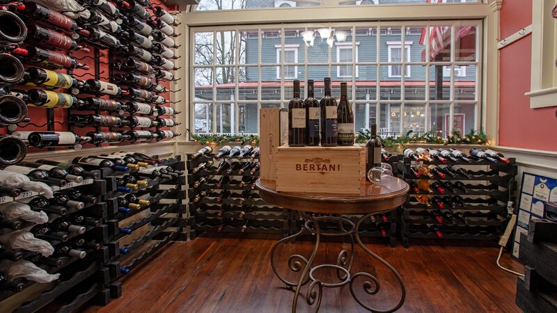 Wine room with bottles of wine on walls and table with wine bottles on top