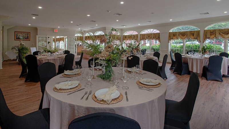Round tables in banquet room with flower arrangements