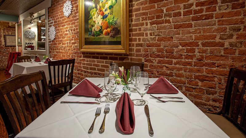 Dining room table set for four with brick wall and painting decoration